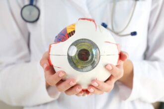 Doctor holding model of an eyeball