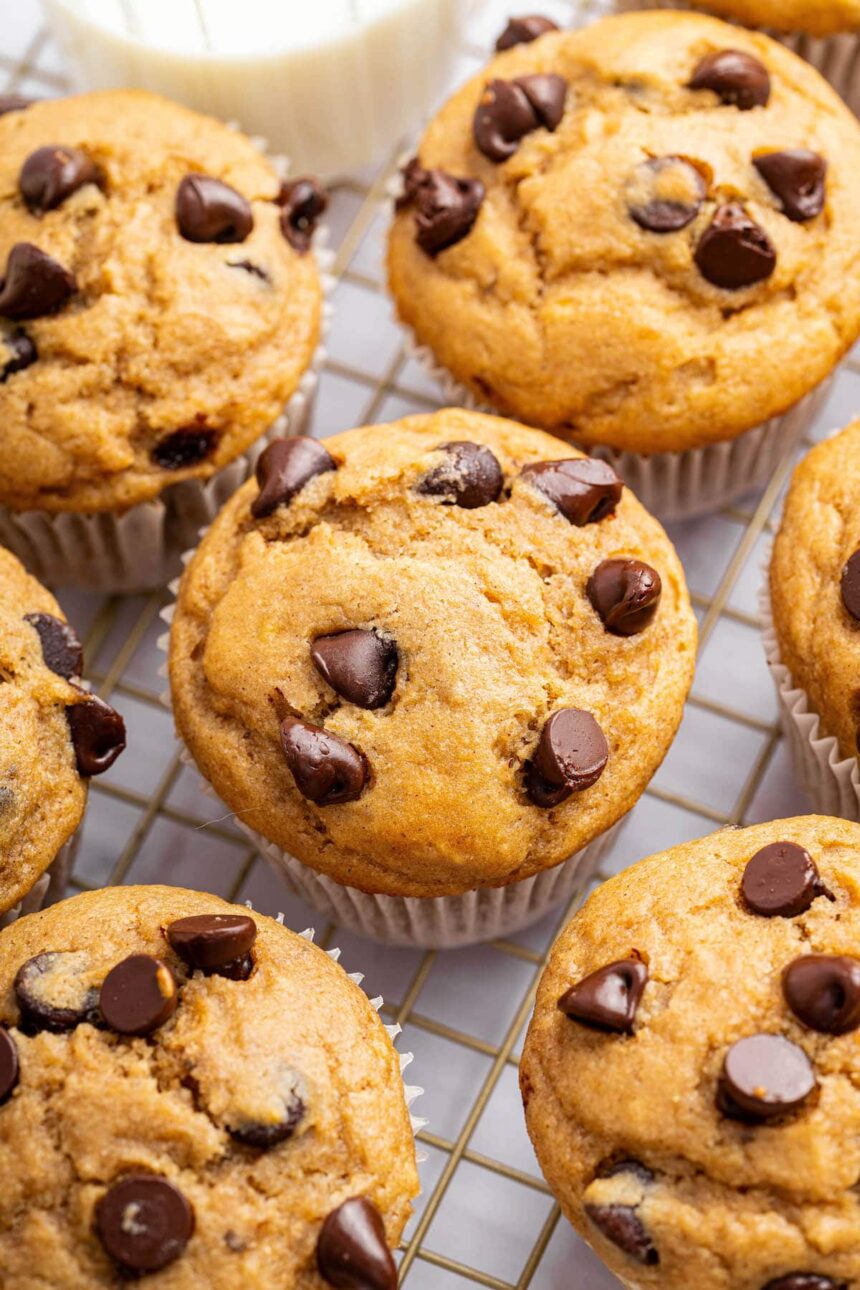 Kodiak cake muffins with chocolate chips on top, cooling on a wire rack.